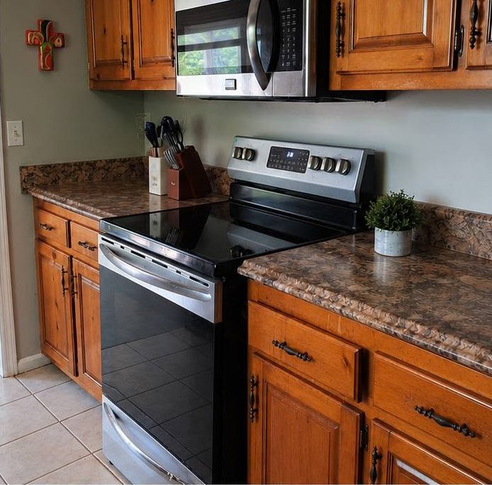The same kitchen counter and stove cleared and wiped clean