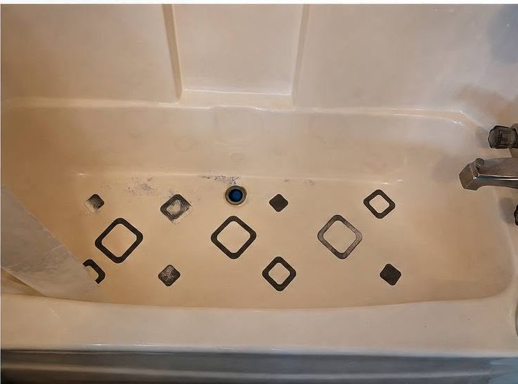A bathtub with staining and soap build-up before cleaning